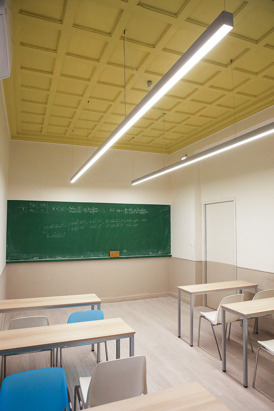 Rectangular gypsum ceiling, green blackboard, warm grey vinyl floor and grey wall are components of this classroom